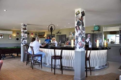 a bar in a restaurant with people sitting at a counter at 47 Lochview in Stranraer