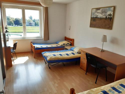 a room with two beds and a desk and a desk sidx sidx sidx at Salwator Apartments in Krakow