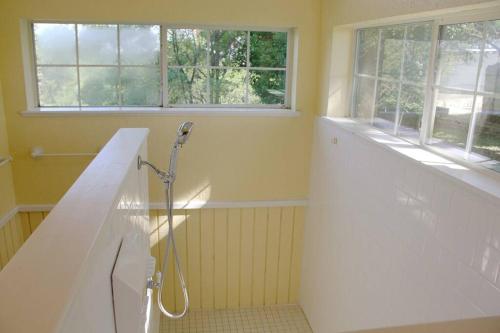 ein Bad mit einer Dusche und einem Waschbecken in der Unterkunft Amah's Cabin ~ Silver Spur Dancehall Ruins ~ in Bandera