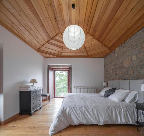 a bedroom with a large bed and a wooden ceiling at Casa da Moiroa in Sendim