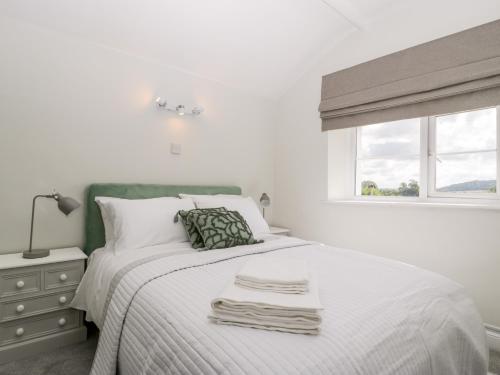 a white bedroom with a bed with towels on it at Somerset House in Bridgwater