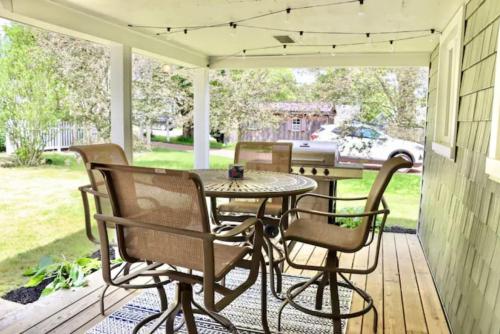 een patio met een tafel en stoelen op een veranda bij 4 bdr Cottage, Edinboro Lake Views, Dogs Welcome in Edinboro