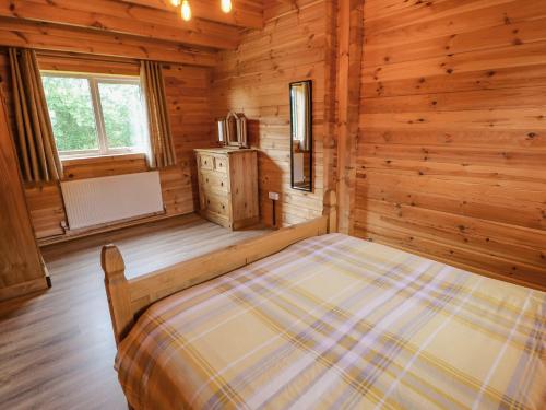 a bedroom with a bed in a wooden cabin at Curlew in Barnard Castle