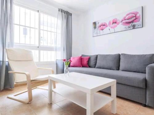 a living room with a couch and a coffee table at Apartamento con patio y piscina cerca de Sevilla in La Algaba
