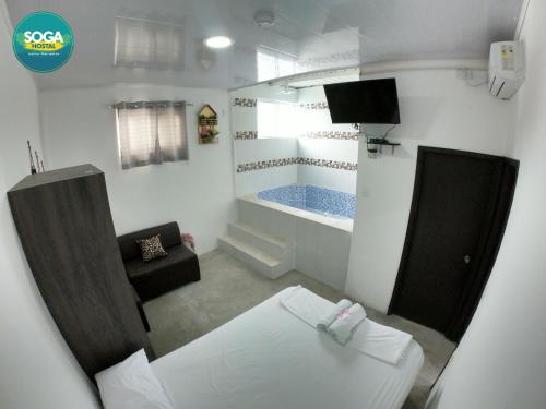 a small room with a bed and a bath tub at Soga Hostal in Santa Marianita