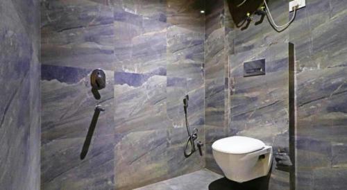 a bathroom with a toilet and a phone on the wall at Hotel Sohrai Inn in Rānchī