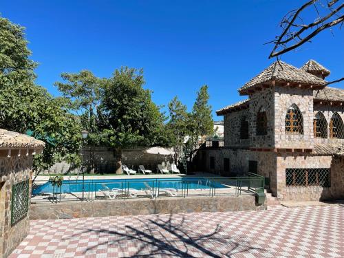 a house with a swimming pool in a yard at Casa Rural La Moraleja in Villanueva del Arzobispo