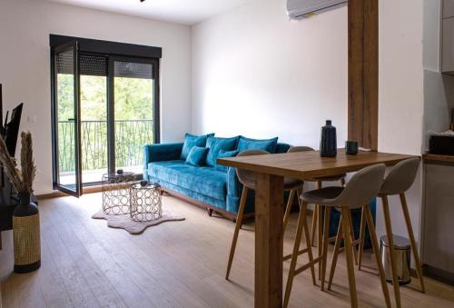 ein Wohnzimmer mit einem blauen Sofa und einem Tisch in der Unterkunft Apartment Ilija in Tivat