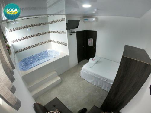 a small room with a bed and stairs in it at Soga Hostal in Santa Marianita