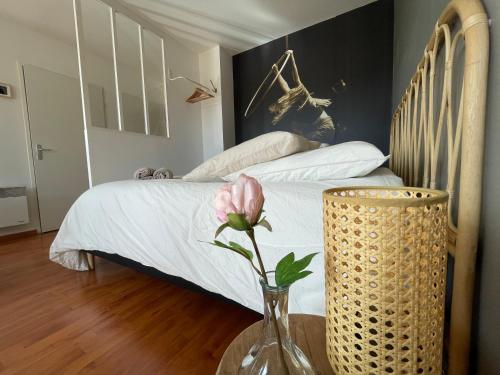 - une chambre avec un lit et un vase avec une fleur dans l'établissement El Circo foch, à Châlons-en-Champagne