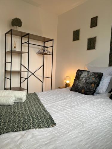 Appartement Evry في Évry-les-Châteaux: غرفة نوم مع سرير أبيض ورف