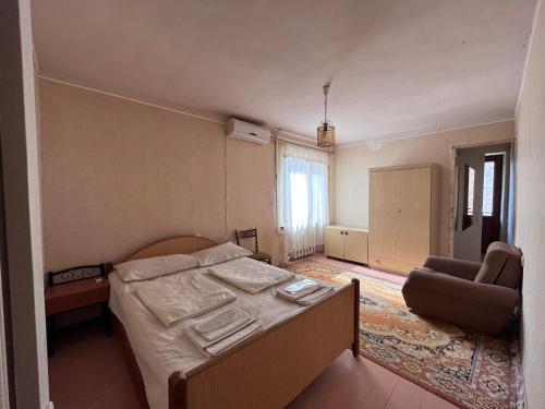 a bedroom with a bed and a chair in it at Apricot Tree B&B in Yeghegnadzor