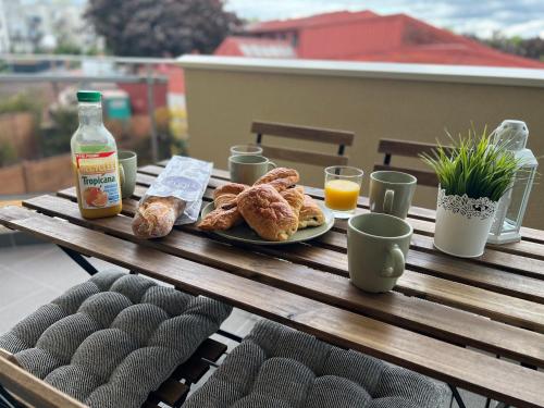 einen Tisch mit einem Teller Gebäck und Orangensaft in der Unterkunft Appartement Evry in Évry-les-Châteaux