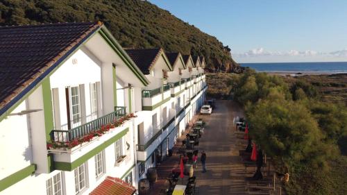 una fila de edificios en una colina junto al océano en Hostal de Berria, en Santoña
