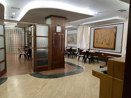 Habitación con comedor con mesas y sillas. en Alojamientos Cervantes, en Linares