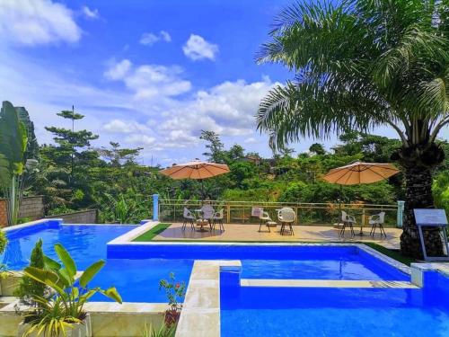 uma piscina com cadeiras e guarda-sóis ao lado de um resort em Mont Bleu Hôtel em Assougoula Emo