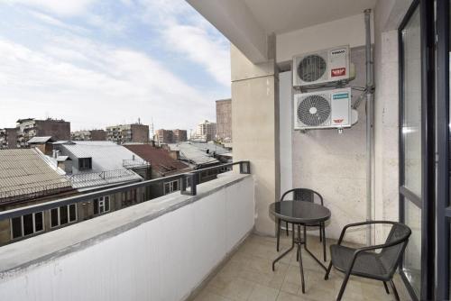 a balcony with a table and chairs and a view at Rent Inn Yerevan on Koghbaci Street in Yerevan
