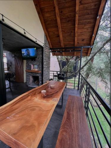 a wooden bench on a balcony with a tv at Cabañas San Marcos in Mazamitla