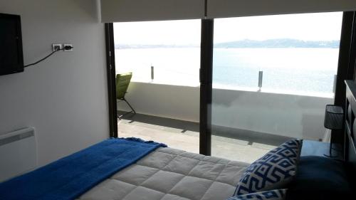 - une chambre avec un lit et une vue sur l'eau dans l'établissement Departamento Jardin del Mar La Serena, à Coquimbo
