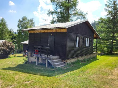 a small cabin with a bench in a yard at Toska rekreační středisko in Prostřední Bečva