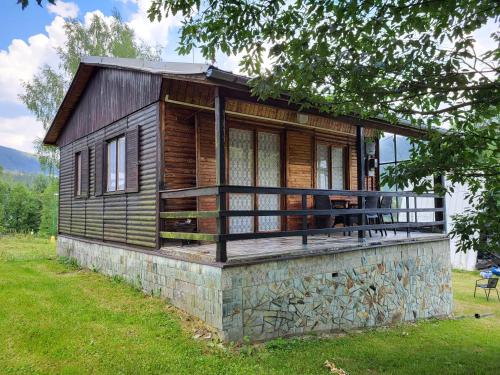 a wooden cabin on a stone wall in the grass at Toska rekreační středisko in Prostřední Bečva
