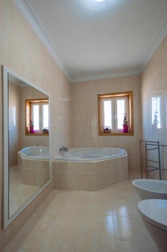 a large bathroom with two tubs and two sinks at Sorte do Castelo in Marco de Canaveses