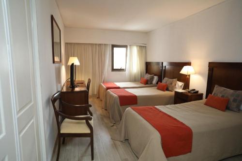 una habitación de hotel con 2 camas y una silla en HR Esmeralda Luxor en Buenos Aires