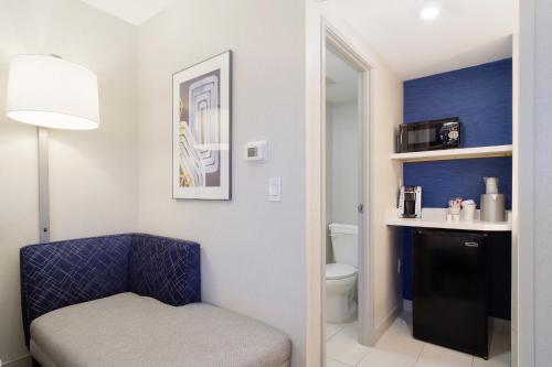 a bathroom with a blue chair and a toilet at Holiday Inn Express & Suites Phoenix - Tempe, an IHG Hotel in Tempe