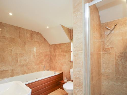 ein Badezimmer mit einer Badewanne, einem WC und einem Waschbecken in der Unterkunft Ellenhall Farm Cottage in Stafford