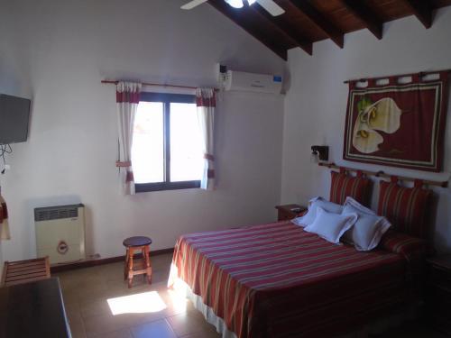 a bedroom with a large bed and a window at Aldea Blanca in Merlo