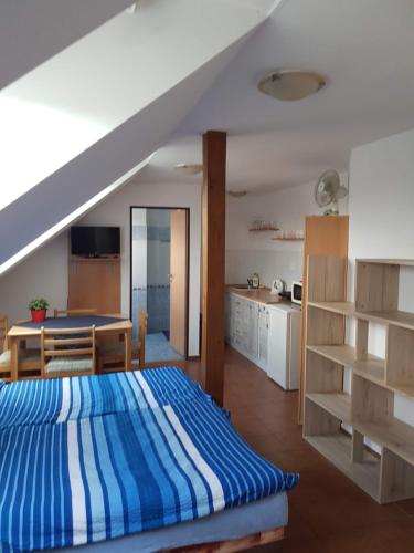 1 dormitorio con 1 cama azul y blanca y cocina en Penzion U Polenů en Třeboň