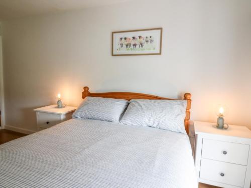 um quarto com uma cama com duas mesas de cabeceira em Fisherman's Cottage em Llandysul