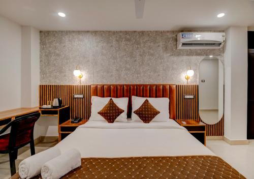 Habitación de hotel con cama, escritorio y espejo. en Hotel Sai Rain Tree en Guwahati