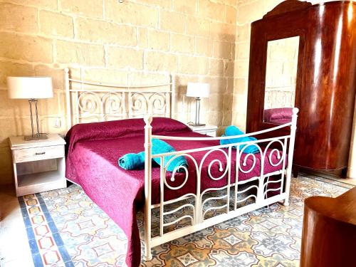 a bedroom with a white bed with a pink blanket at Birbuba House 2 in Għarb