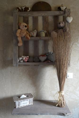 a shelf with teddy bears and other items on it at Chambres d'hôtes "La Bouill'hôte" in Langensoultzbach