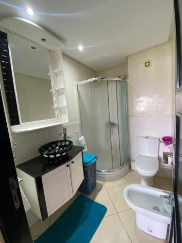 a bathroom with a toilet and a sink and a shower at Superbe appartement en résidence avec piscine in Casablanca