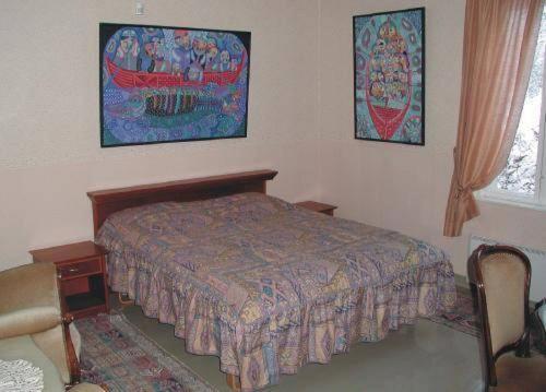 a bedroom with a bed and two pictures on the wall at Villa Nurminata in Parikkala