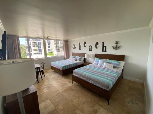 a bedroom with two beds and a table at Beachfront condo in Miami! in Sunny Isles Beach