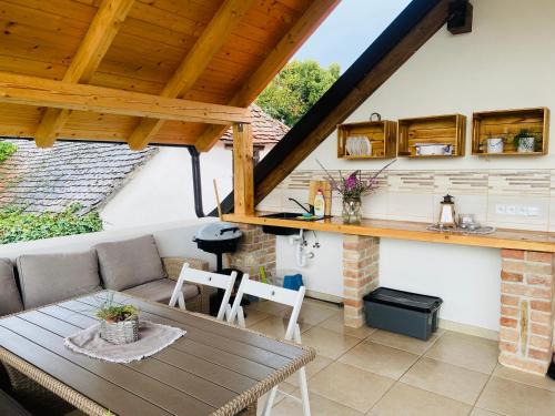 eine Terrasse mit einem Tisch und eine Küche in einem Haus in der Unterkunft Na domečku in Březí