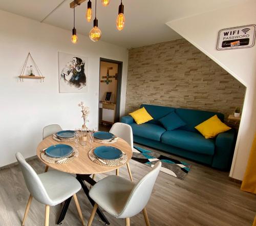 salon ze stołem i niebieską kanapą w obiekcie Studio Capucine - Centre ville - Jolie vue - Cosy w mieście Eu