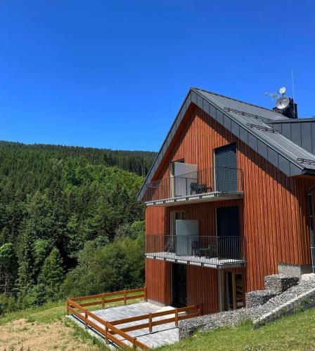 a red building with a balcony on the side of it at Prima Apartmán Dolní Morava in Dolní Morava