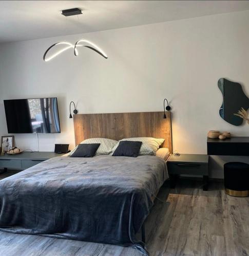 a bedroom with a large bed with a wooden headboard at Prima Apartmán Dolní Morava in Dolní Morava