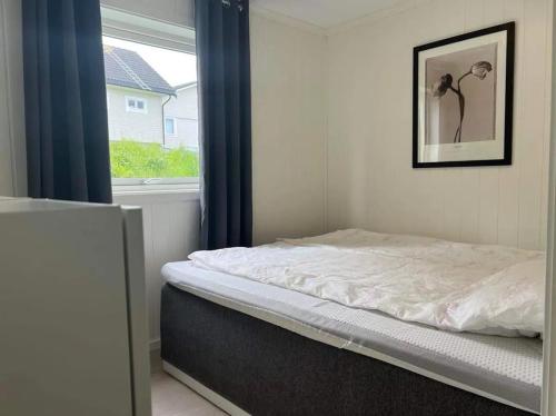 Cama en habitación con ventana en Lekkert gjestehus med gratis parkering på stedet. en Levanger