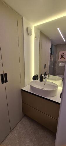 y baño con lavabo blanco y espejo. en Stay in Kaunas & Radio City - Free Parking, en Kaunas