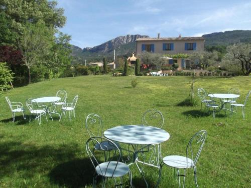 a group of tables and chairs in a field at Freundliches Haus mit Pool und großem Garten in Buis-les-Baronnies