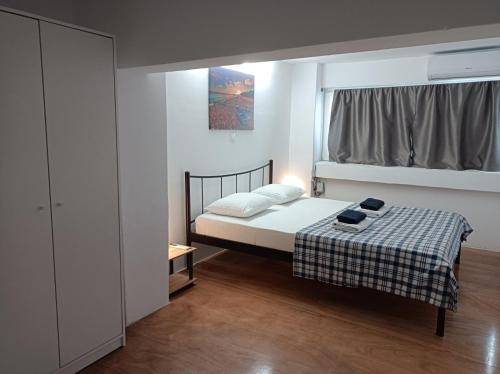 een kleine slaapkamer met een bed en een raam bij Apartment Dipla in Athene