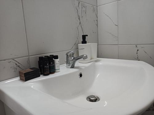 een witte wastafel in een badkamer met een spiegel bij Apartment Dipla in Athene