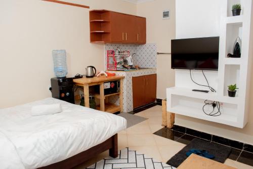a bedroom with a bed and a small kitchen at Shalom Apartments in Naivasha