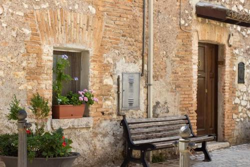 una panca di legno seduta di fronte a un edificio di Jo Sedio Residenza, Bellezza e Relax Monti Lepini a Carpineto Romano
