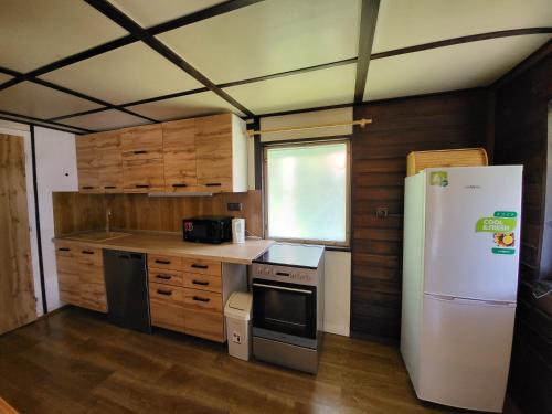 a kitchen with a white refrigerator and wooden cabinets at Toska rekreační středisko in Prostřední Bečva